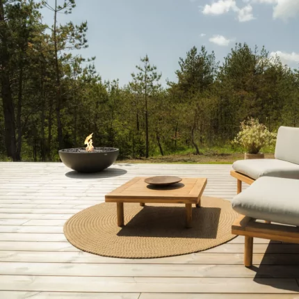 Modern outdoor living space with the contemporary Mix 850 fire pit creating warmth and atmosphere on a patio beside a glass-walled home